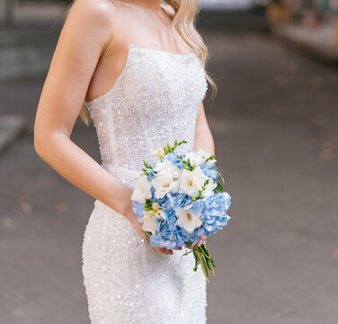 Bride holding blue white wedding bouquet