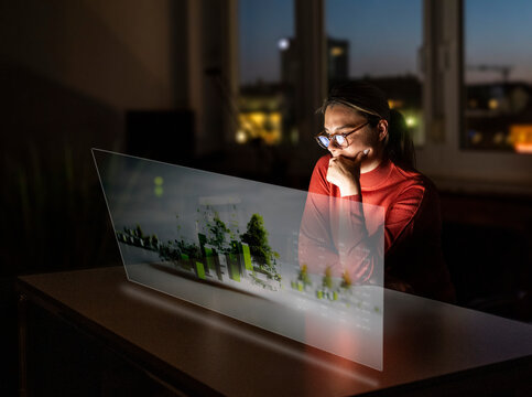 Woman analyzes AI city data on a transparent screen in the office