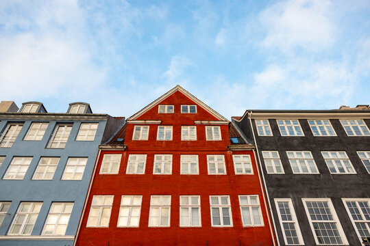Colorful houses stand on Nyhavn in Copenhagen under a blue sky