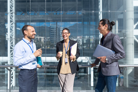 Business colleagues enjoy a coffee break outside a modern office
