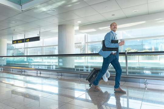 A businessman rushes to the departure gate with his suitcase