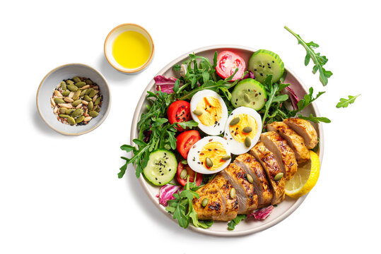 High protein lunch bowl with chicken, eggs and vegetable salad isolated