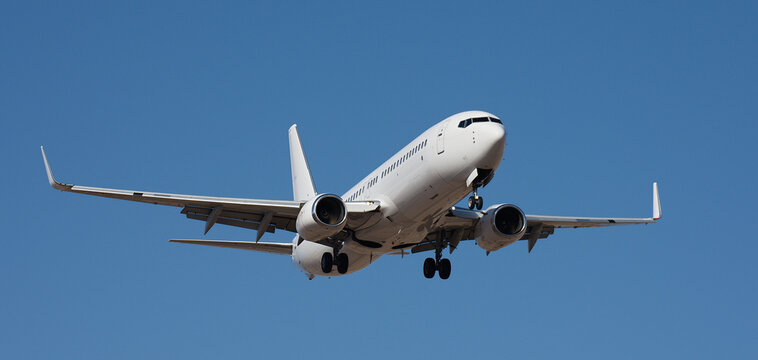 The plane lands, passenger airliner. The plane lands. Airplane, passengers flying in the blue sky, preparing to land at the airport