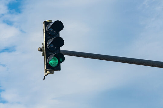 Traffic light showing green against a blue sky