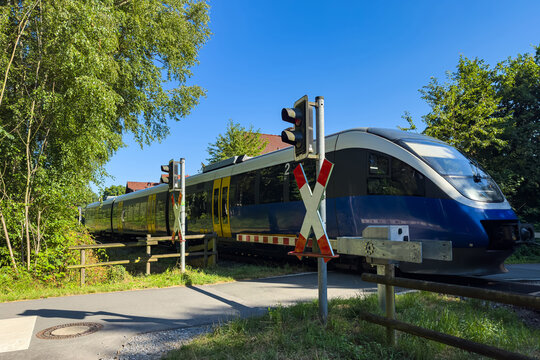 Modern Passenger Train Crossing a Railway Level Crossing in Germany