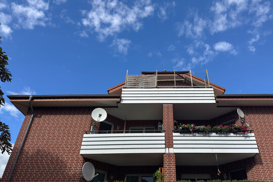 A brick building with balcony and blue sky in a residential area