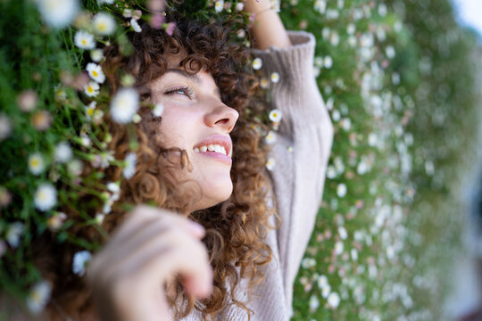 White woman with curly hair lies smiling