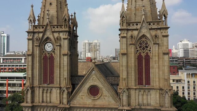 Revealing drone shot flying around well preserved Sacred Heart Cathedral in central residential neighborhood in Guangzhou - China religion and travel 