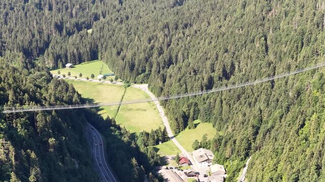 Suspension footbridge spans a forested Alpine valley near Burgruine Ehrenberg, Reutte, Tyrol, Austria