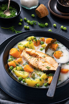 A large steak of cooked salmon in creamy soup