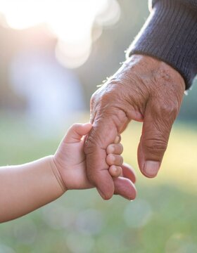 old man holding baby hand
