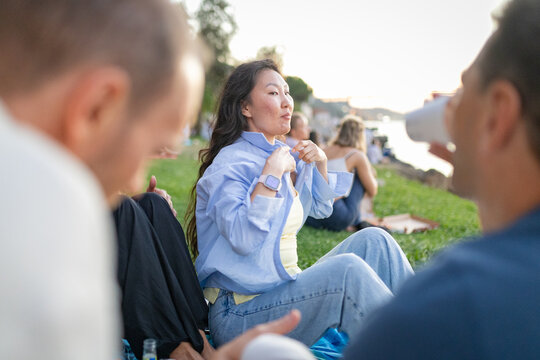 Young woman enjoying picnic with friends outdoors