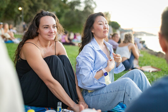 Diverse women friends enjoying outdoor conversation during picnic