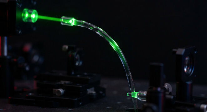 Liquid-core optofluidic waveguide guiding brilliant fluorescent green laser beam via total internal reflection in advanced photonics research
