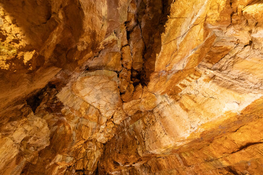Exploration of cave walls showing rock formations and textures in a natural setting