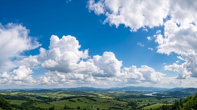 Panoramic View of Green Rolling Hills Lake and Fluffy Clouds Under Bright Blue Sky 澄み渡る青空と白い入道雲の下に広がる緑豊かな丘陵と湖の爽やかで雄大な田園風景