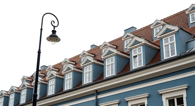 Blue building exterior with dormer windows and a street lamp