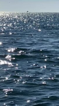Loopable abstract background of blue ocean water ripples with beautiful sparkling sun reflections.