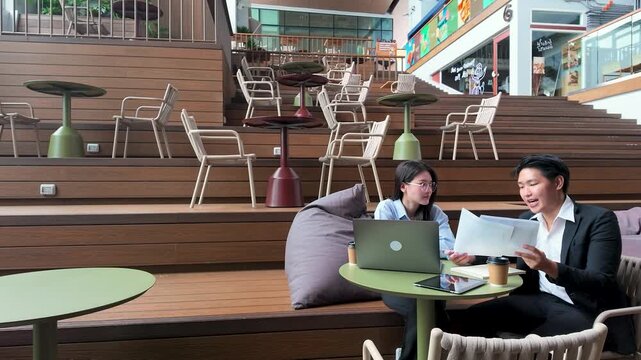 Asian Business Colleagues Reviewing Financial Reports in Modern Coworking Space