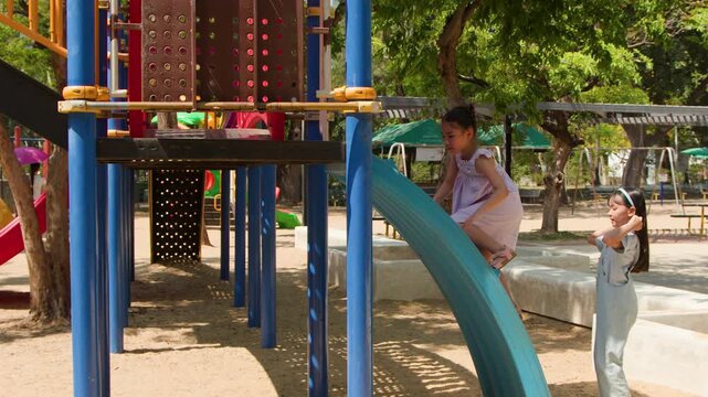 Asian Children Playing on Outdoor Playground Equipment in Lumpini Park