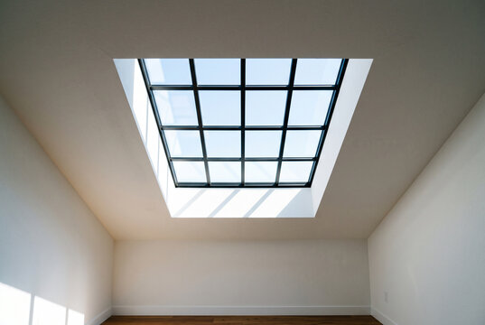 Skylight with dramatic backlit effect creating silhouette of frame on ceiling