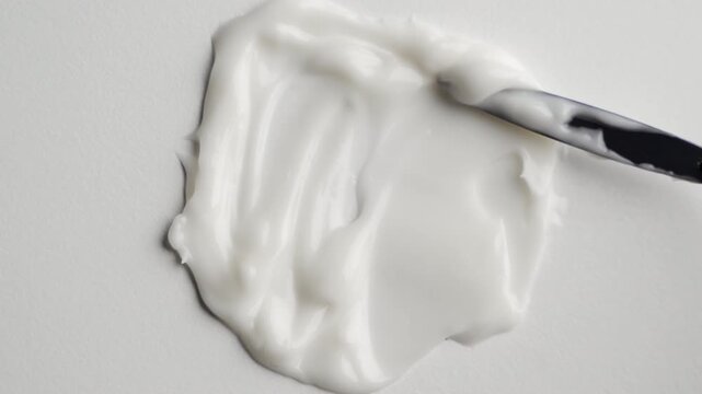 White cosmetic cream texture smearing on a blue background in a macro shot for skincare advertising