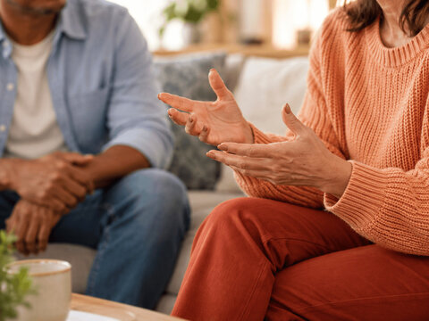 Couple having an argument and expressing disagreement while sitting together in their living room