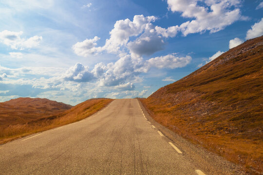 Driving a car on a mountain road. View from the windscreen. Beautiful harsh north minimalist landscape. Nature of Norway. Polar circle. The way to Nordkapp (North Cape). Norway