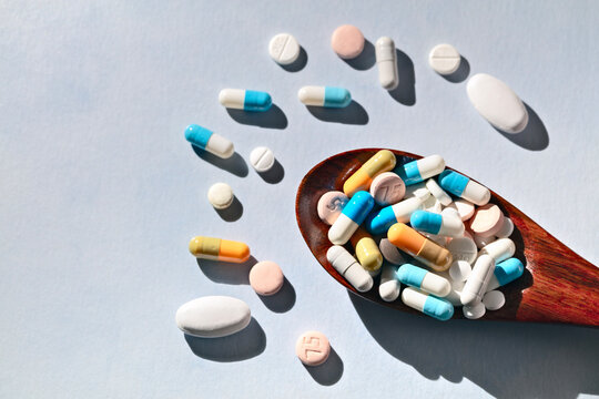 Pills tablets and capsules on spoon health care and prescription medicine background