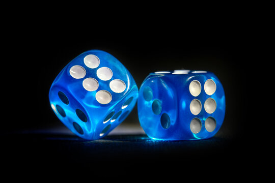 Roll the dice chance, throwing and rolling blue colored neon dice on a dark background