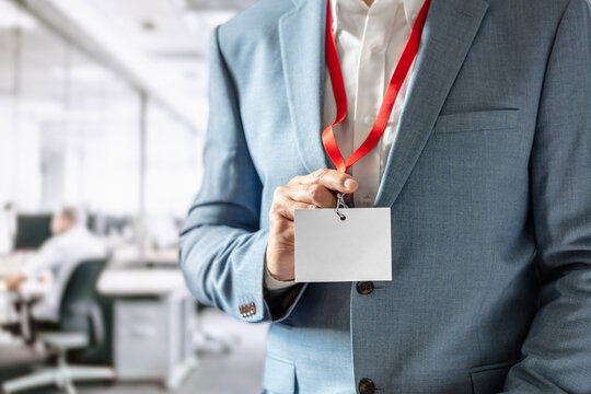 Businessman in office for meeting holding blank ID badge on lanyard