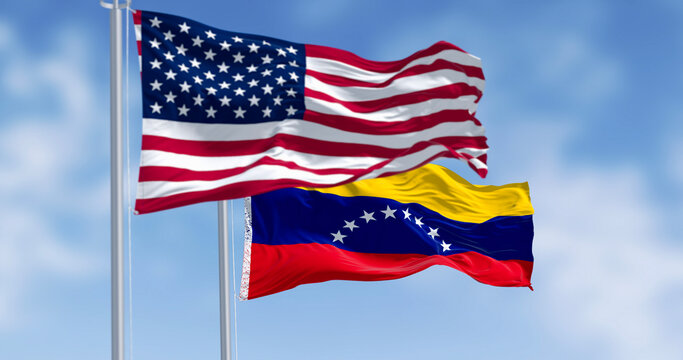 Venezuela and US national flags waving in the wind on a clear day