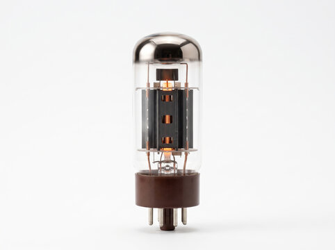 Classic glowing radio tube amplifier component standing upright isolated against a seamless clean white studio background.