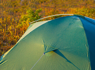 closeup part of green touristic tent  on grass background, outdoor camping background © Yuriy Kulik