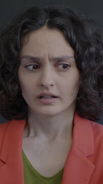 Portrait of shocked young lady looking at camera shaking head on black color background. Negative emotion and people concept.