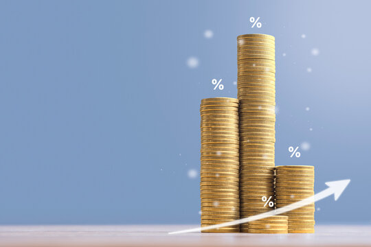 Stacks of gold coins forming growth chart with rising arrow and percent icons on blue background. Interest rate increase, capital investment, dividend growth and wealth accumulation concept.