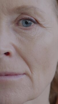 Close-up portrait of unhappy mature woman pursing lips looking at camera on gray color background. People and negative emotion concept.