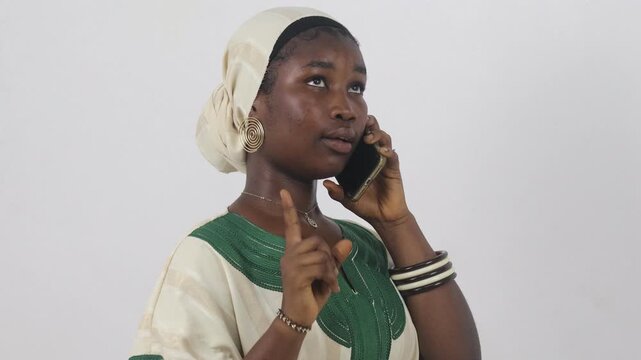 Young African woman on the phone making a finger gesture