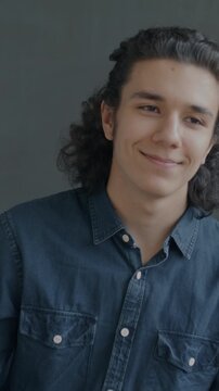 Slow motion portrait of happy Hispanic man dancing looking at camera on black background. Party mood and entertainment concept.