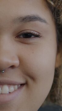 Close-up portrait of cheerful African American girl half face smiling on black background. Emotion and expression concept.