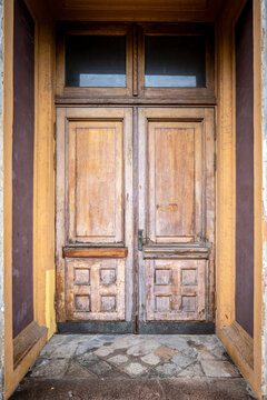 Weathered Wooden Double Door Framed by a Historic Recessed Entrance