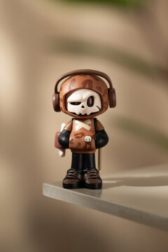 A Mr. Bone art toy from a time traveling blind box series stands on a clear platform.