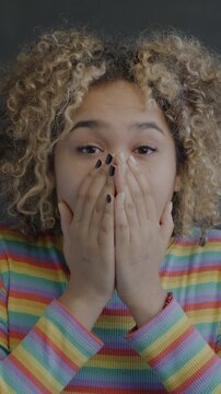 Portrait of surprised and shocked African American woman looking at camera on black background. Face expression and emotion concept.