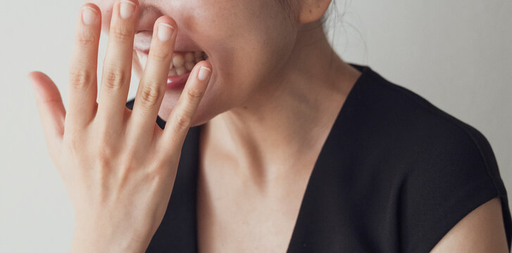 Smiling Woman Covering Face With Hand