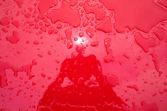Water Droplets on Bright Red Surface With Reflection