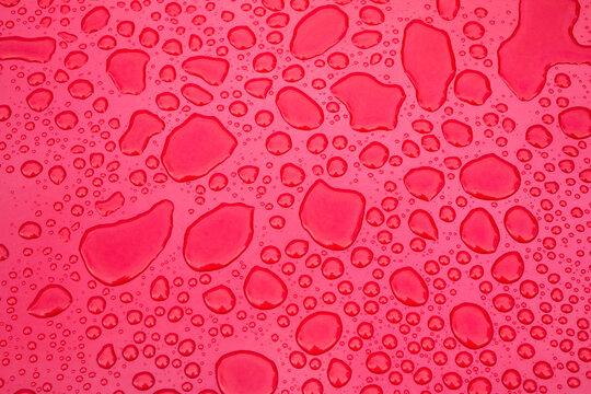 Water Droplets Forming Abstract Pattern on Red Surface