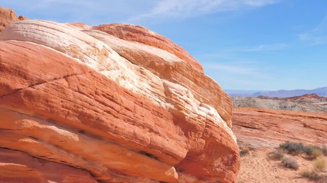 Slow camera movement revealing stunning red sandstone formations and arid desert landscape of valley of fire state park in nevada on bright, sunny day with blue skies overhead