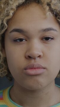 Portrait of serious African American woman looking at camera on black color background. People and face expression concept.