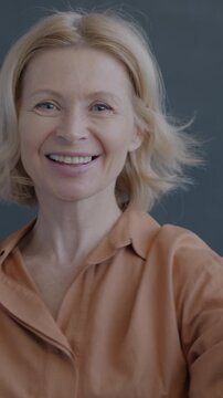 Portrait of beautiful mature woman dancing smiling looking at camera on black background. Entertainment and party time concept.