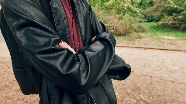Person in leather jacket standing outdoors